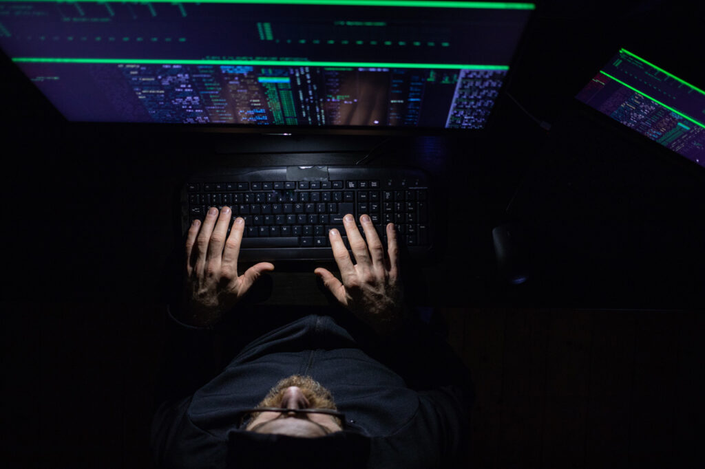 imagen de hacker  frente a monitores de ordenador picando codigo